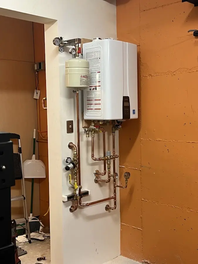 Plumbing technician inspecting water heater connections in Creswell